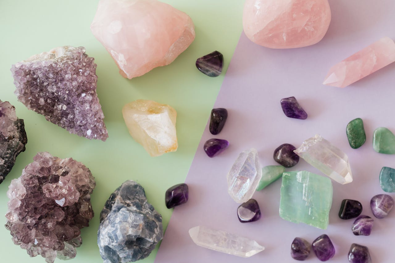 why-choose-us-02 A variety of crystals and gemstones including amethyst and rose quartz on a pastel background.